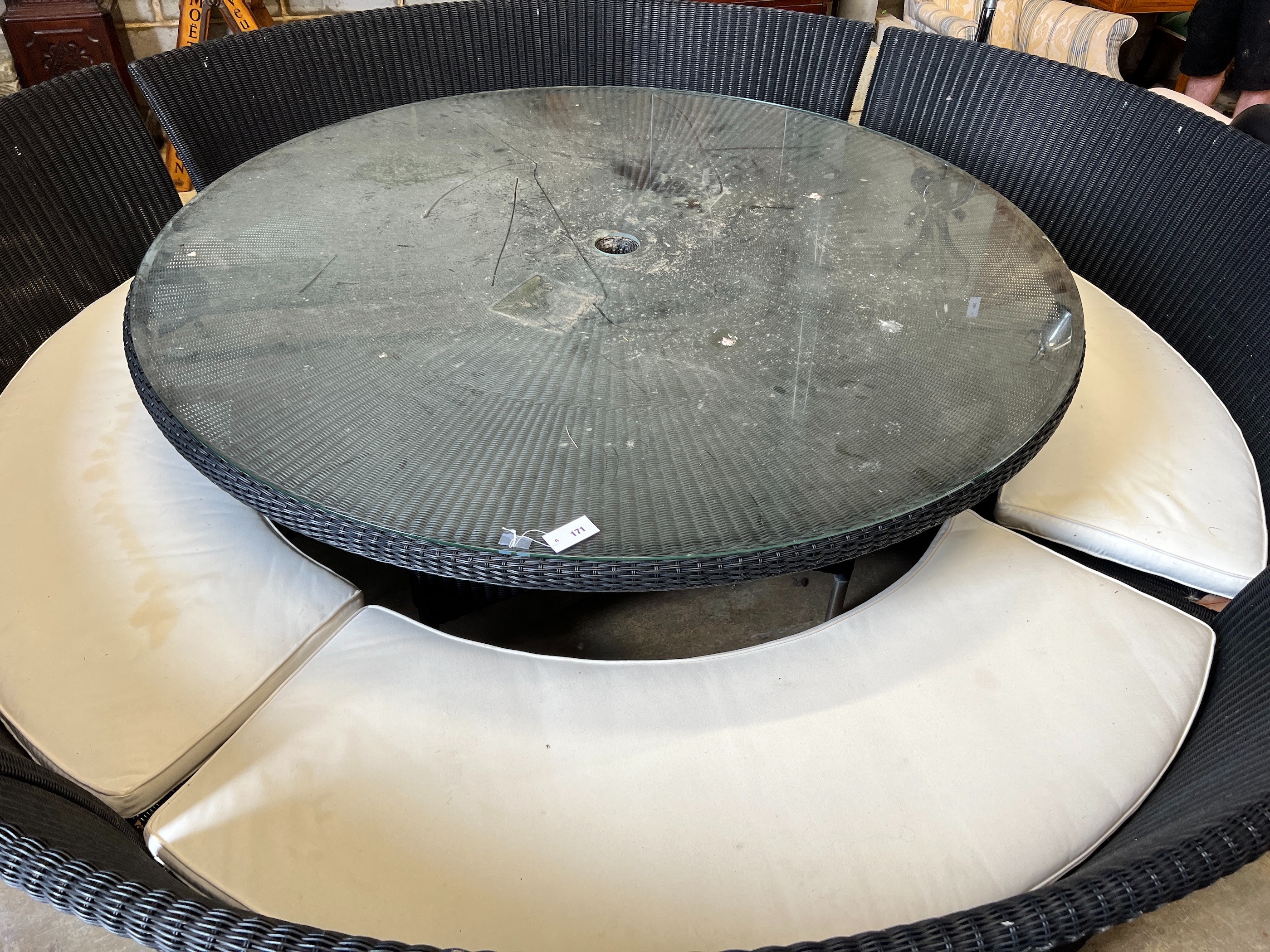 A large Westminster black all weather rattan circular topped garden table, diameter 180cm, height 74cm, together with four curved back seats and cushions